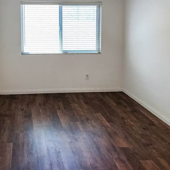 a room with a ceiling fan and a window with blinds.