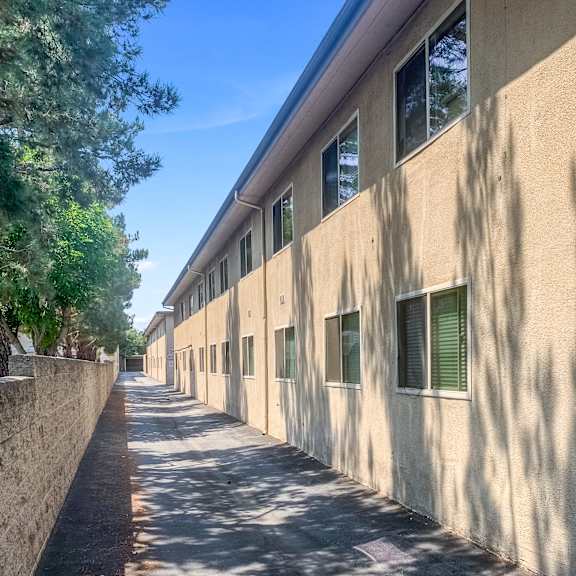 a long building with windows and trees on the side.