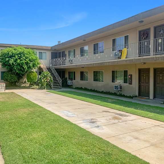 a sunny day at a residential building with a well-kept lawn.