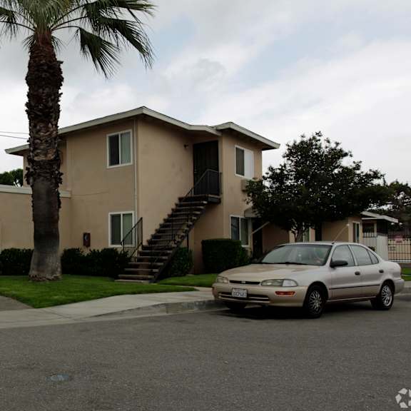 a white car is parked in front of a house.