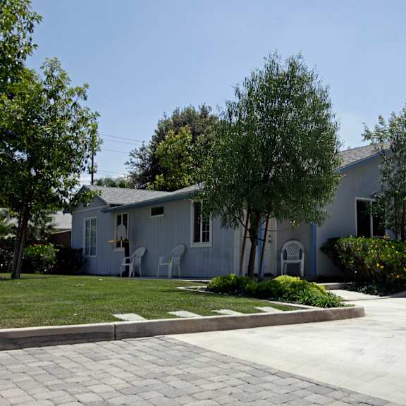 a white house with a driveway in front of it.