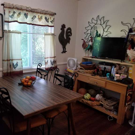 a wooden dining table with chairs and a bowl of fruit on it.