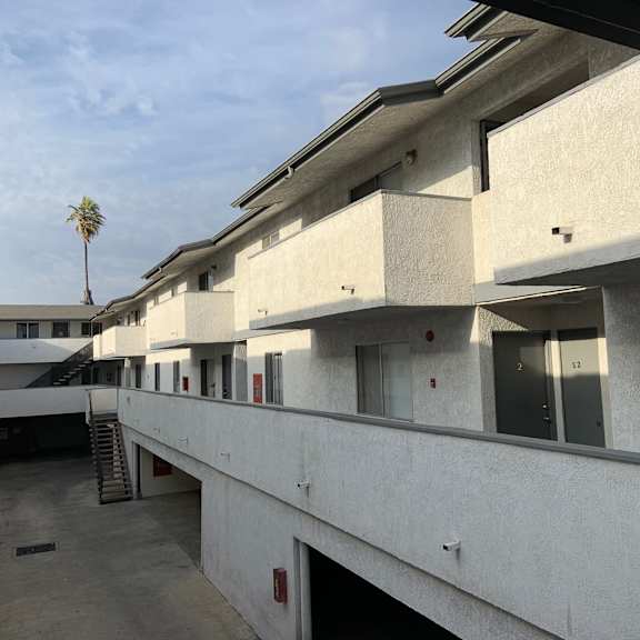 a concrete building with a palm tree in the background.