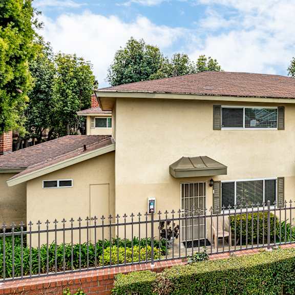 a house with a brown roof and a black fence.