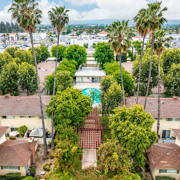 a view of a courtyard surrounded by houses and trees.