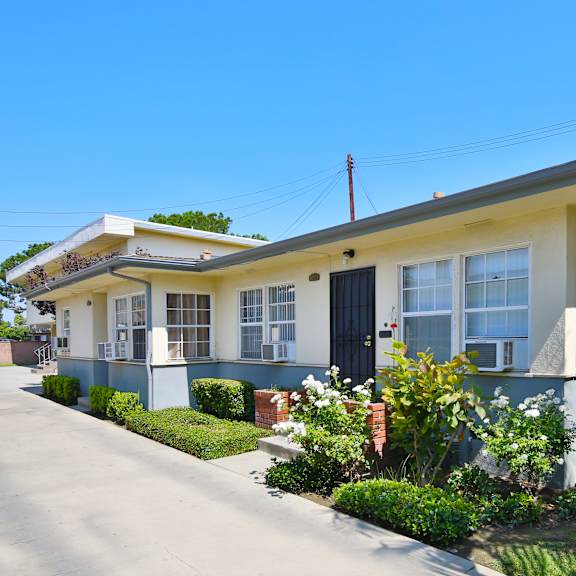 a house with a blue and yellow exterior and a red telephone pole in the front yard.