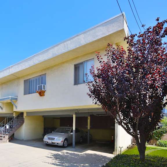 a two-story house with a garage and a tree in front.