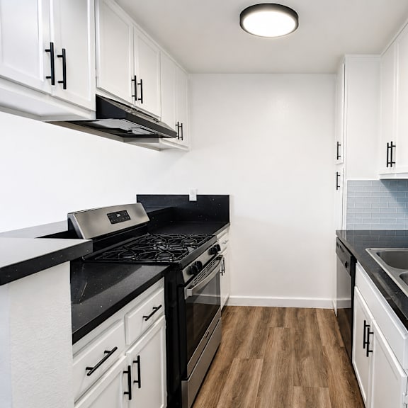 a kitchen with black countertops and white cabinets.