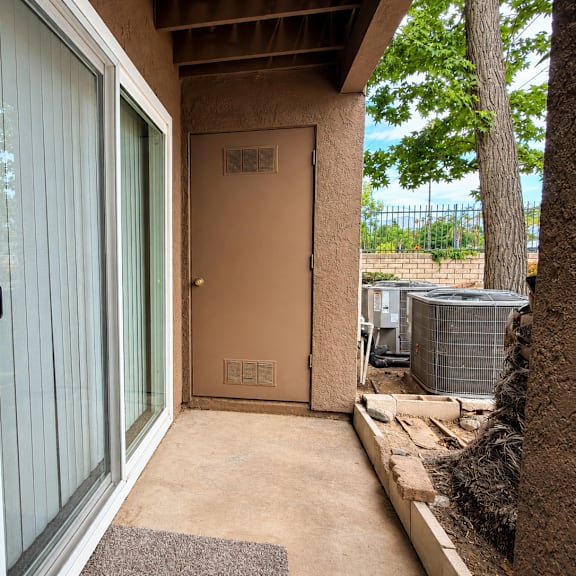a brown door with a window to the left is closed.
