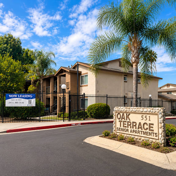 a sign for oak terrace senior apartments is in front of a building.