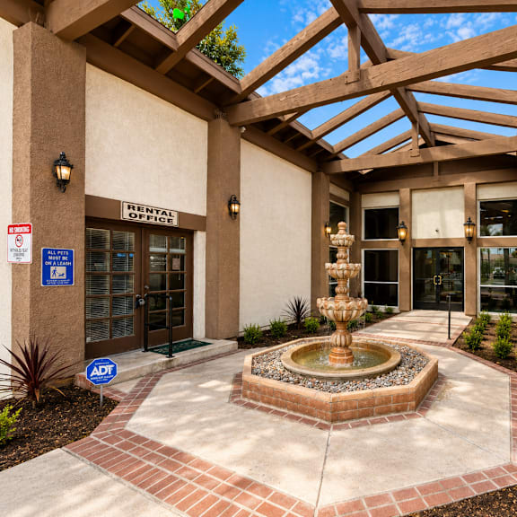 a courtyard with a fountain in the middle of it.