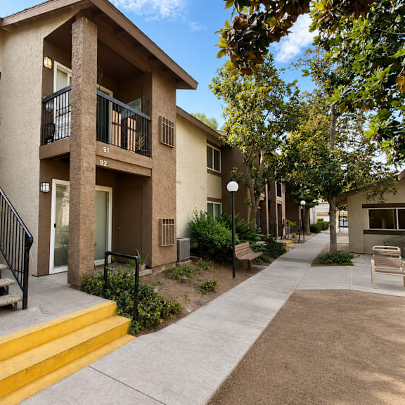 a row of apartment buildings with a yellow staircase leading to the front door.