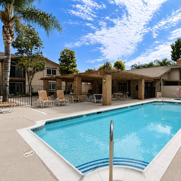 a large swimming pool in front of a house.