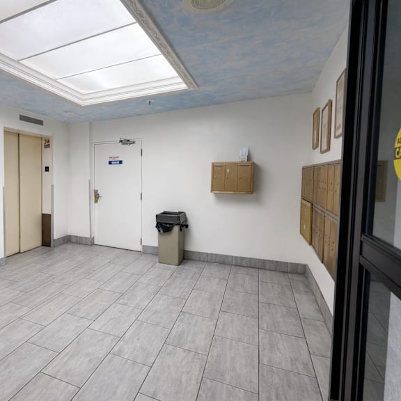 a hallway with a trash can and a door.
