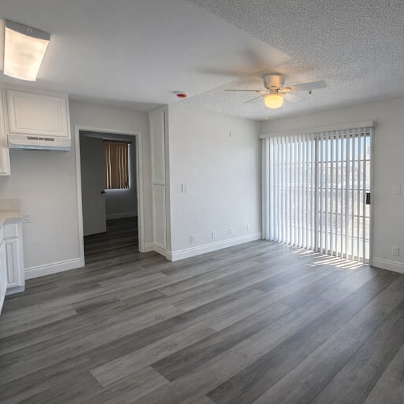 a room with a ceiling fan and a window with blinds.