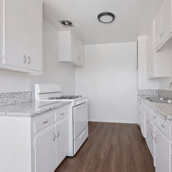 a kitchen with white cabinets and granite countertops.