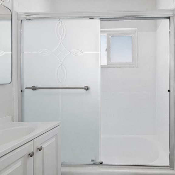 a white bathroom with a glass shower door.