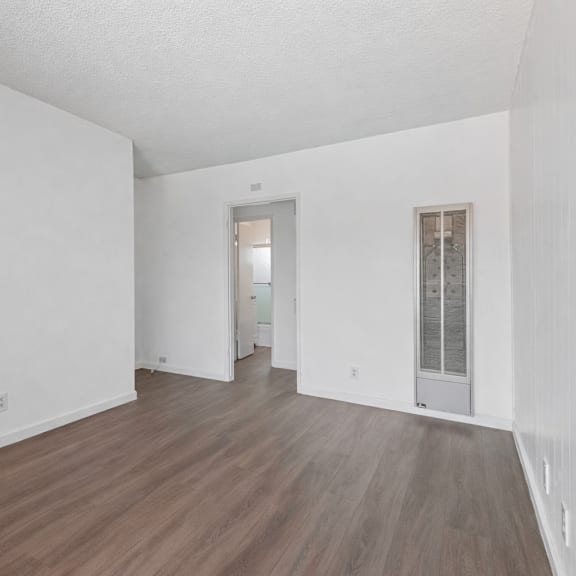 a room with wooden flooring and white walls.