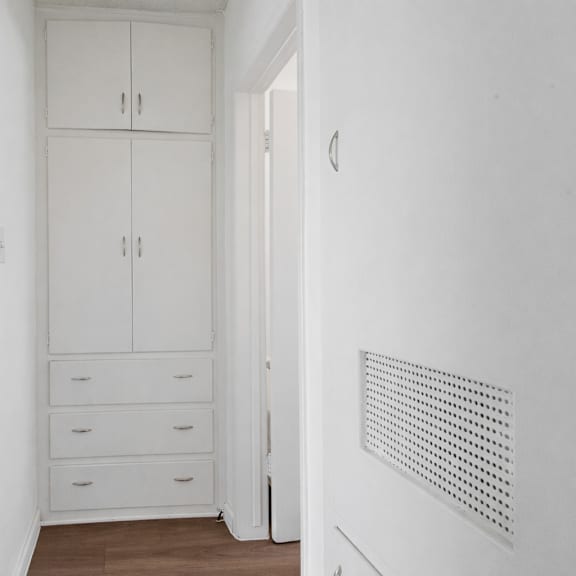 a white room with a cabinet and drawers.