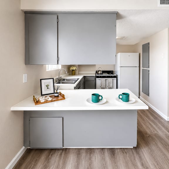 a kitchen with a white countertop and grey cabinets.
