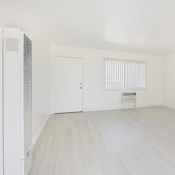 a room with a white door and a window with blinds.