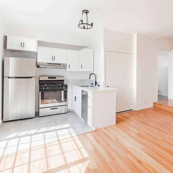 a kitchen with wooden floors and white walls.