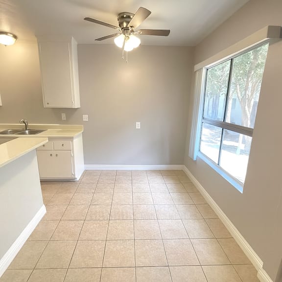 a kitchen with a fan and a window.