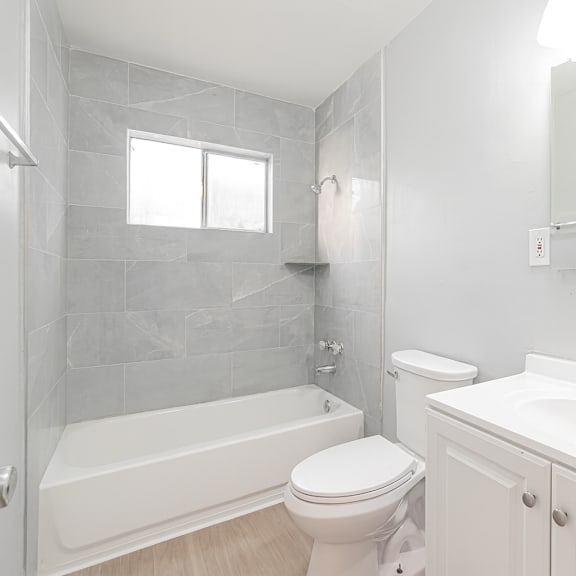 a white bathroom with a toilet, sink, and tub.