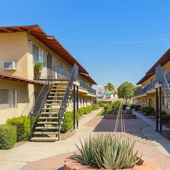 a sunny day at a residential area with houses and staircases leading to the front doors.