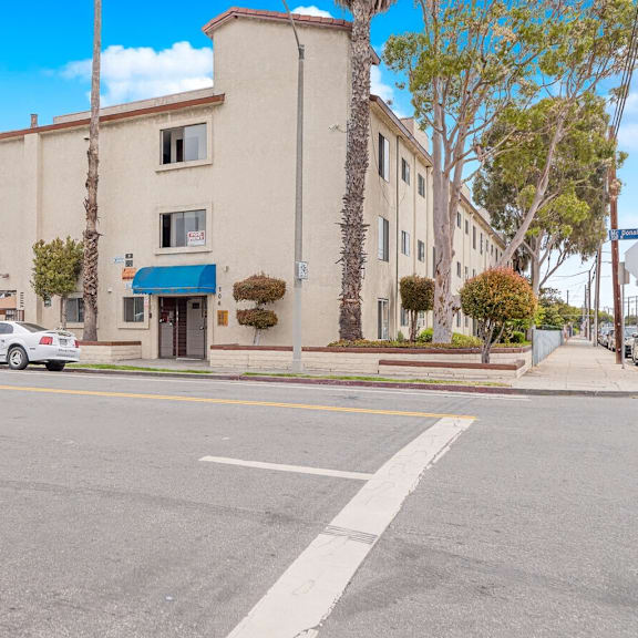 a white car is parked in front of a building with a blue awning.