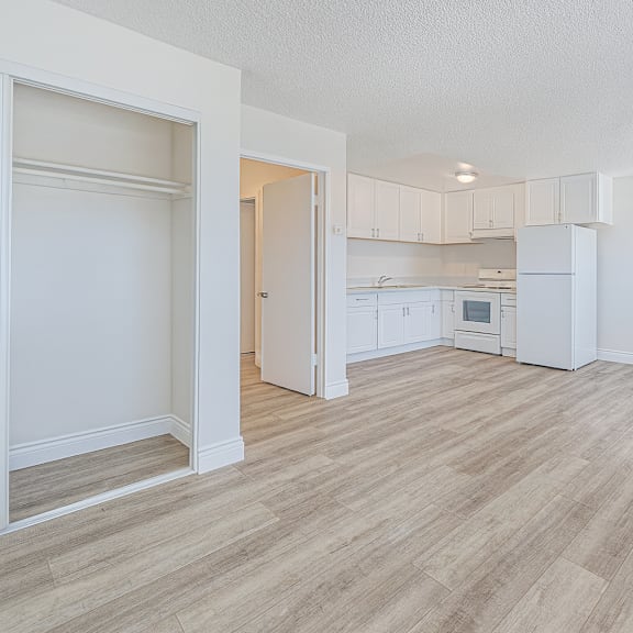 a kitchen area with a refrigerator, sink, and cabinets.