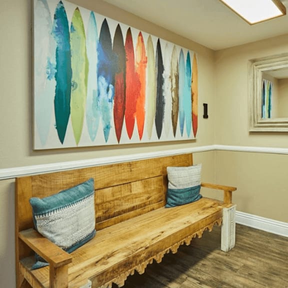 a bench and a painting in a room with a mirror at huntington terrace north senior, huntington beach, ca 92648