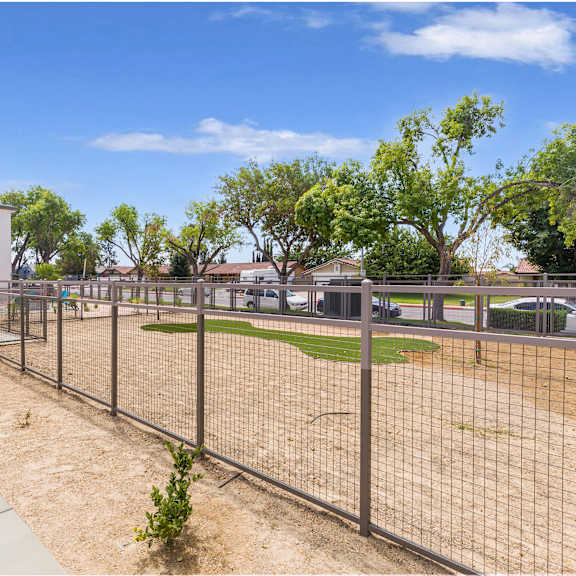 a fenced area with a building in the background.