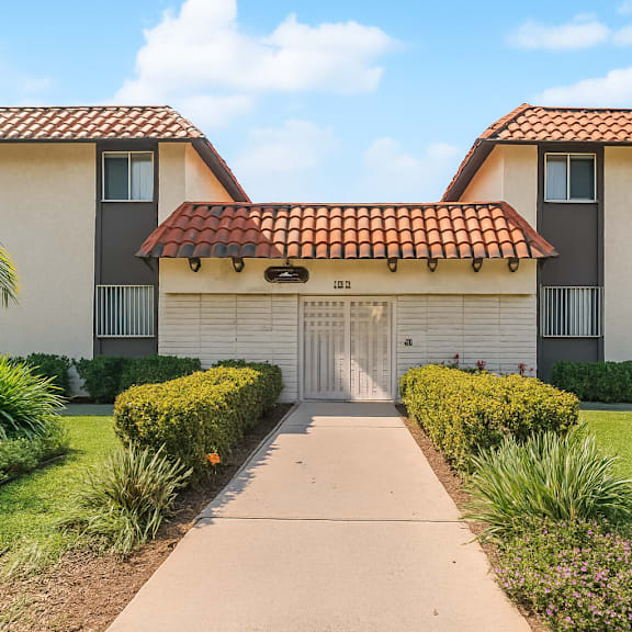 a building with a red tile roof and a white garage door.
