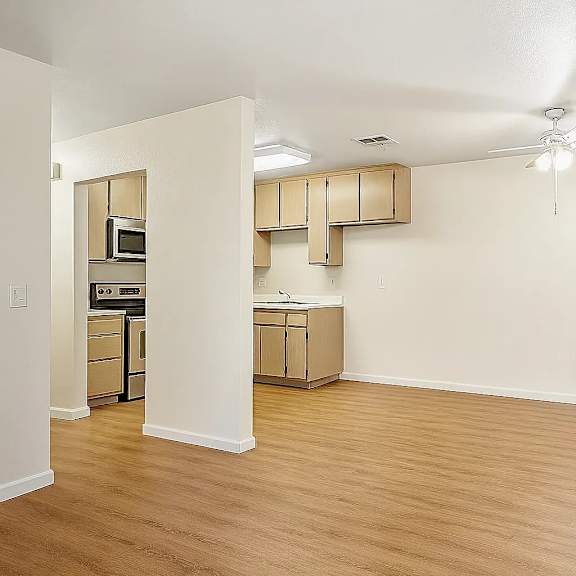 a room with a ceiling fan and wooden flooring.