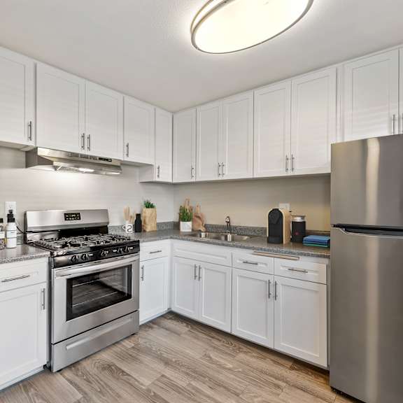 a modern kitchen with white cabinets and stainless steel appliances.