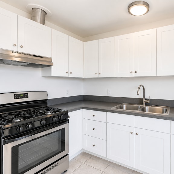 a kitchen with white cabinets and a stainless steel stove.