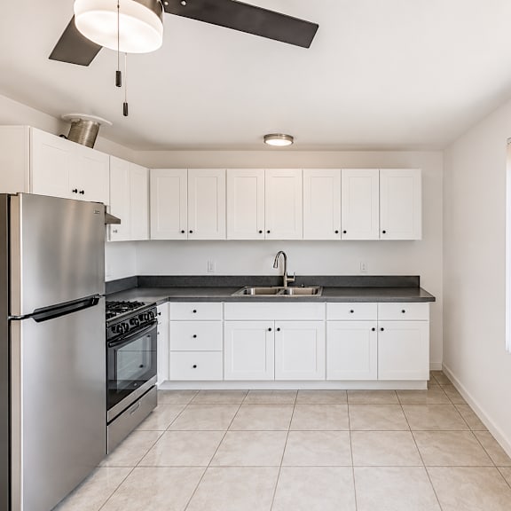 a kitchen with white cabinets and a stainless steel refrigerator.