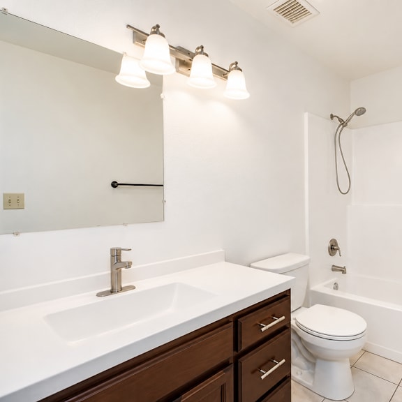 a white bathroom with a sink, toilet, and bathtub.
