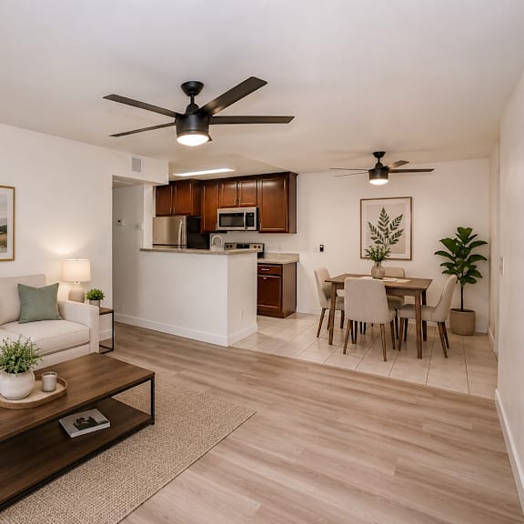 a living room with a white couch, a coffee table, and a dining table with chairs.