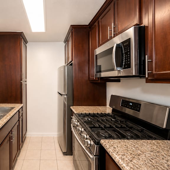 a kitchen with brown cabinets and granite countertops.