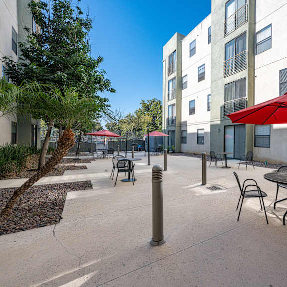 a red umbrella is on a table outside a building.