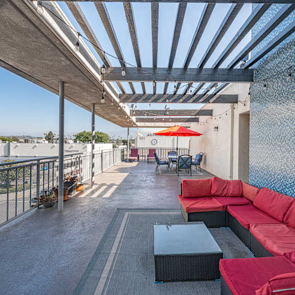 a patio with red couches and a table.
