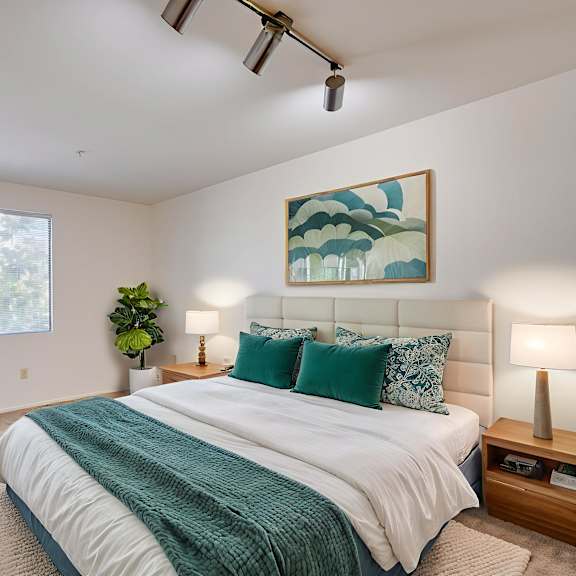 a bedroom with a large bed and a painting on the wall.