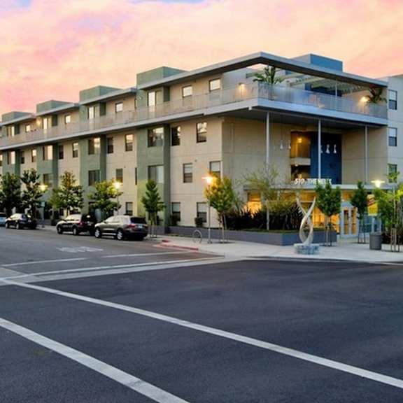 a large apartment building with a parking lot in front of it at helix at university village, california