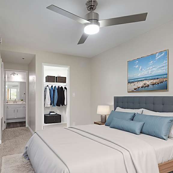 a bedroom with a large bed and a ceiling fan.