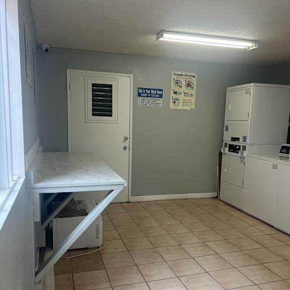 a room with a white wall and a white ceiling with a ventilation system.