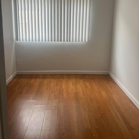 a room with a ceiling fan and wooden wall paneling.
