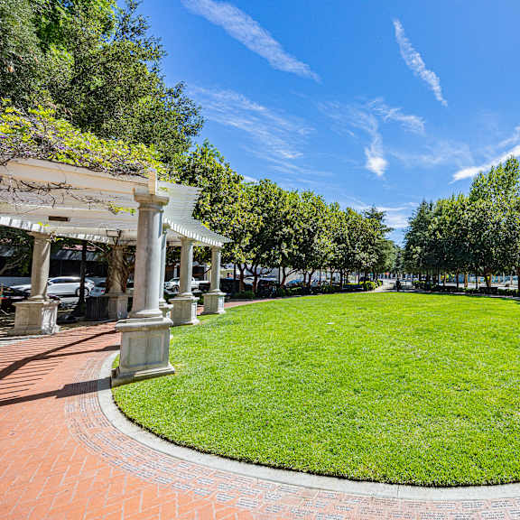 a grassy area surrounded by columns and trees.