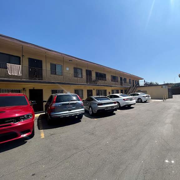 a parking lot with several cars parked in front of a building.